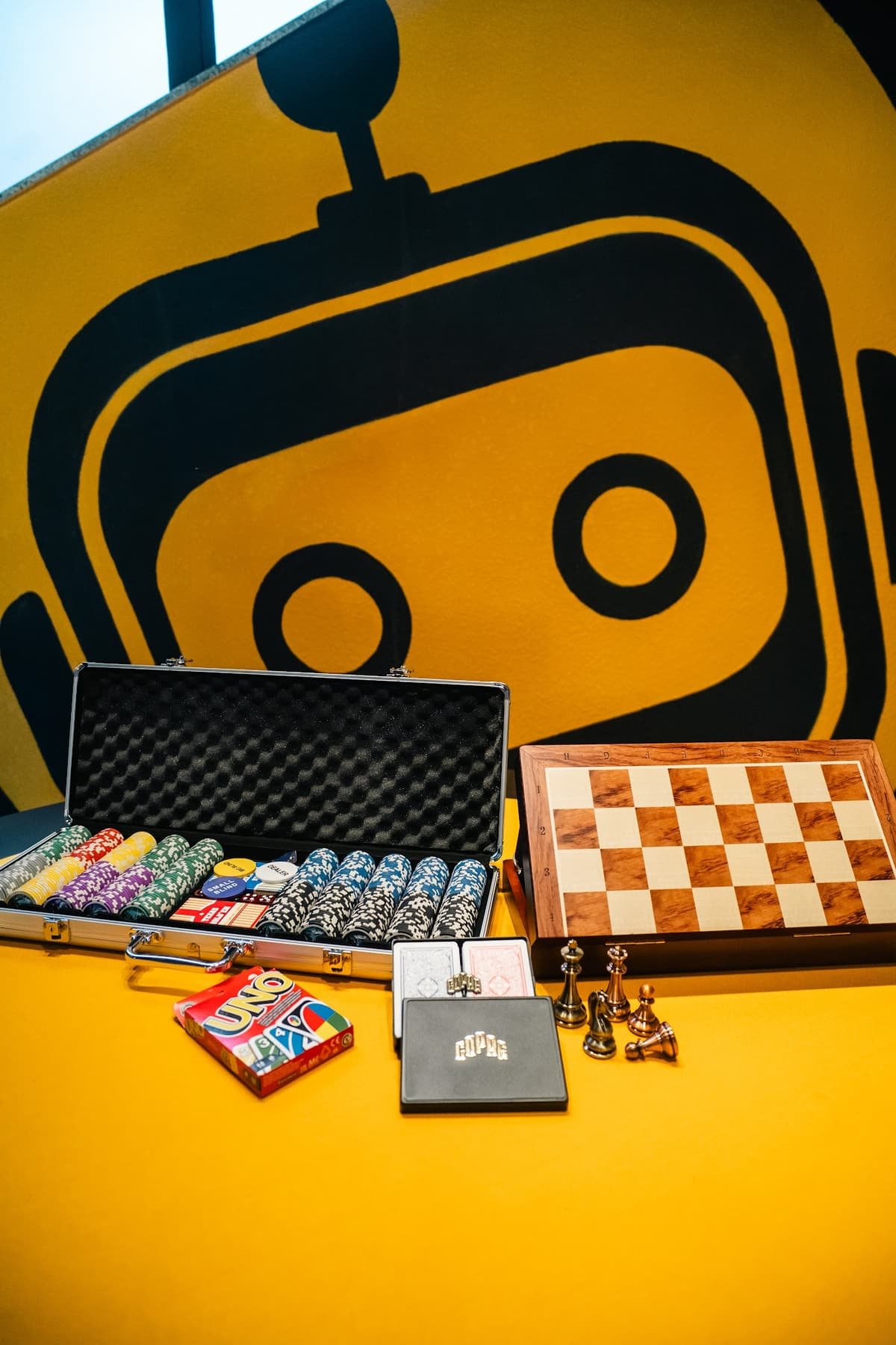 Mesa de poker e xadrez com o robô ao fundo